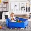 A baby playing in a ball pit next to a crib. Anteprima dell’immagine prodotto