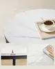 A collage of images showing a round coffee table with a marble top, a cup of coffee, and a hand wiping water from the surface. Náhled obrázku produktu