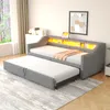 A grey upholstered daybed with a pull-out trundle bed is set up in a room with a window and a framed picture on the wall. Voir les images du produit