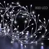 A close-up shot of a string of white LED lights resembling branches with buds, against a black background. Produktbild-Vorschau