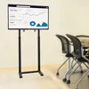 A TV floor stand with a monitor displaying a graph in an office setting. Podgląd zdjęcia produktu
