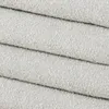 A close-up view of stacked, textured fabric, likely a boucle upholstery material. Produktbild-Vorschau