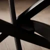 Close-up abstract view of black metal legs of a table, possibly a coffee table, against a wooden floor background. Produktbild-Vorschau