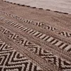 A close-up view of a woven rug with geometric patterns. Produktbild-Vorschau