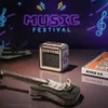 A wooden model of an electric guitar and amplifier are displayed on a reflective surface, with a neon "MUSIC FESTIVAL" sign in the background. Voir les images du produit