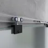 A close-up view of a sliding glass door system, showing the track and rollers against a concrete wall. Produktbild-Vorschau