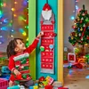 A child is interacting with a Christmas advent calendar hanging on a wall, with a decorated Christmas tree in the background. Produktbild-Vorschau