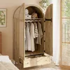 An open wardrobe with clothes hanging inside, a drawer pulled out, and a plant on a shelf above. Produktbild-Vorschau