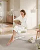 A woman is sitting in a chair reading a book in a well-lit room. Náhled obrázku produktu