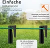 Two black ground stakes holding a green cable in a grassy outdoor setting. Podgląd zdjęcia produktu