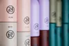 A close-up view of several colorful 24Bottles stacked vertically. Produktbild-Vorschau