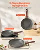 A set of three aluminum frying pans with wooden handles, displayed on a countertop with some limes and a small red fruit. One pan is on a portable induction cooktop. Anteprima dell’immagine prodotto