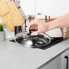 A hand is placing a glass lid on a gas stove. Produktbild-Vorschau