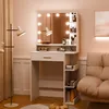 A white vanity table with a mirror and lights, set up in a room with pink walls and a beige sofa. Produktbild-Vorschau