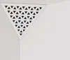 A white triangular acoustic foam panel with a perforated HDF plate is shown in a corner where two walls meet. Produktbild-Vorschau