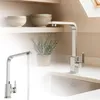 A modern kitchen sink with a chrome faucet and a potted rosemary plant on the counter. Produktbild-Vorschau