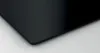 A close-up view of a black induction hob. Voir les images du produit