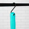 A teal handle of a cleaning tool is hanging from a black hook on a black rod, against a white brick wall. Voir les images du produit