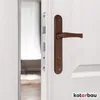 A close-up shot of a brown door handle and lock mechanism on a white door. Anteprima dell’immagine prodotto