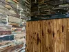 A close-up view of a wall covered in stacked stone and bamboo panels. Anteprima dell’immagine prodotto