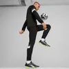 A man is playing soccer indoors, balancing a ball on his foot. Podgląd zdjęcia produktu