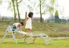Two children playing on a wooden climbing structure in a grassy outdoor area. Voir les images du produit