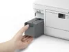 A hand is inserting a gray component into a white printer. Náhľad obrázku produktu
