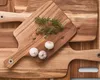 A close-up overhead view of wooden cutting boards with herbs and garlic on one of them. Anteprima dell’immagine prodotto