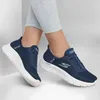 A pair of navy blue Skechers sneakers worn by a person. Anteprima dell’immagine prodotto