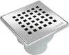 A square stainless steel drain cover with a grid of black square holes, attached to a white plastic drain body. Produktbild-Vorschau