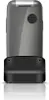 A flip phone is shown docked in its charging base against a white background. Podgląd zdjęcia produktu