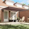 A patio awning extended over a brick patio with outdoor furniture. Anteprima dell’immagine prodotto