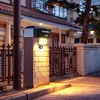 A solar-powered LED floodlight mounted on a stone pillar at night, illuminating the surrounding area. Produktbild-Vorschau