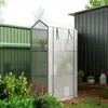 A small greenhouse with plants inside, placed next to a shed and a fence in a garden setting. Produktbild-Vorschau