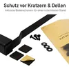 A close-up view of a black metal table leg with accessories like screws and protective pads, along with a packaging bag. Podgląd zdjęcia produktu