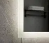 A close-up view of a bathroom mirror with integrated LED lighting, reflecting a shelf with towels. Podgląd zdjęcia produktu