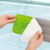 Hands holding a green mop head attachment and a white cleaning pad, with a gray mop head in the background. Produktbild-Vorschau
