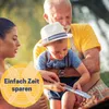 A family is having a barbecue outdoors, with a grandfather holding a young child who is looking at the grill. Produktbild-Vorschau