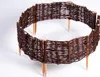 A circular woven willow border with wooden stakes, set against a white background. Produktbild-Vorschau