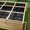 A close-up view of the interior of a wooden raised garden bed, lined with black plastic sheeting and supported by wooden crossbeams. Produktbild-Vorschau