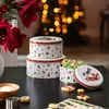 Christmas-themed cookie tins are stacked on a dark table, with cookies and baking ingredients nearby, and a blurred Christmas tree in the background. Produktbild-Vorschau