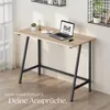 A minimalist desk setup in a room with natural light. The desk has a laptop, a cup, and a small plant on it. There are shelves on the wall behind it. Náhled obrázku produktu