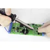 A person is using a soldering iron to work on a green circuit board. Produktbild-Vorschau