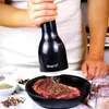 A person is grinding spices onto a steak. Náhled obrázku produktu