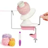 A yarn winder and several balls of yarn are displayed against a white background. A hand is shown turning the crank of the yarn winder. Produktbild-Vorschau