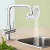 A chrome faucet with a white water filter attached, dispensing water into a stainless steel sink. Fresh mint leaves are visible in the foreground. Produktbild-Vorschau
