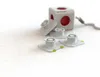 A white PowerCube with red outlets and several white docking stations are arranged on a white surface. Produktbild-Vorschau