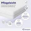 A close-up of a white mattress topper with various feature icons and text overlays. Produktbild-Vorschau