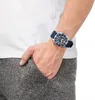 A person's arm wearing a watch, with their hand in their pocket. Anteprima dell’immagine prodotto