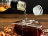 Whiskey being poured from a bottle into a decanter. Podgląd zdjęcia produktu